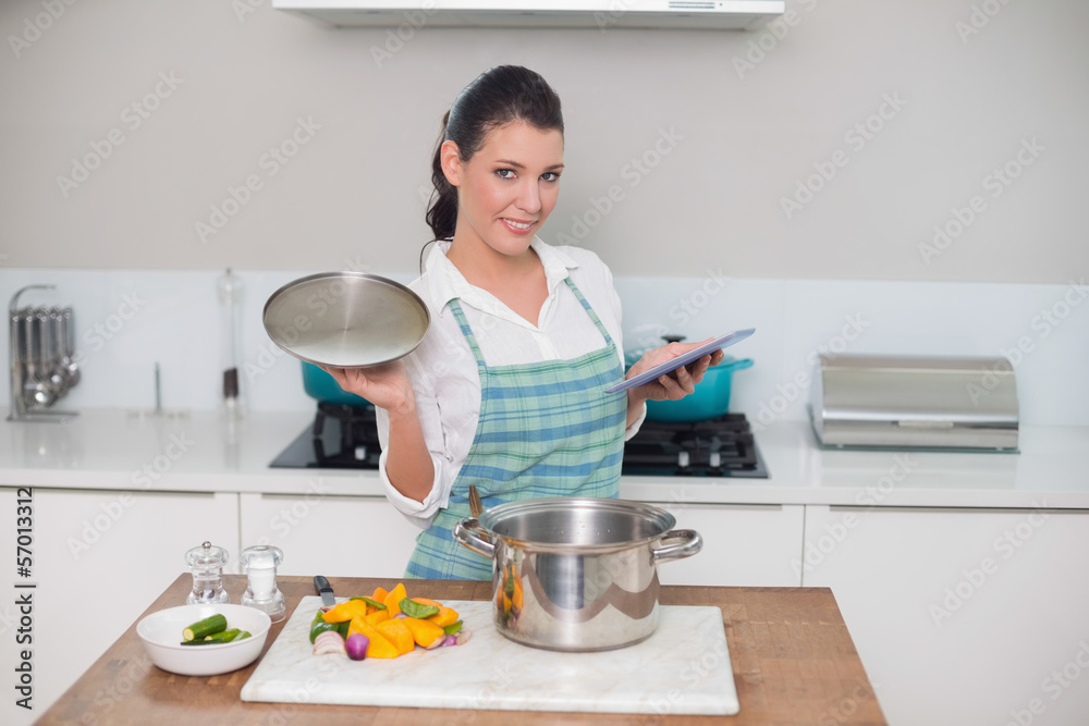 Happy gorgeous woman wearing apron using tablet while cooking Happy gorgeous woman wearing apron using tablet while cooking