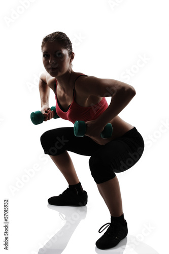 sport young athletic woman doing squatting with dumbbells, silho © Khorzhevska