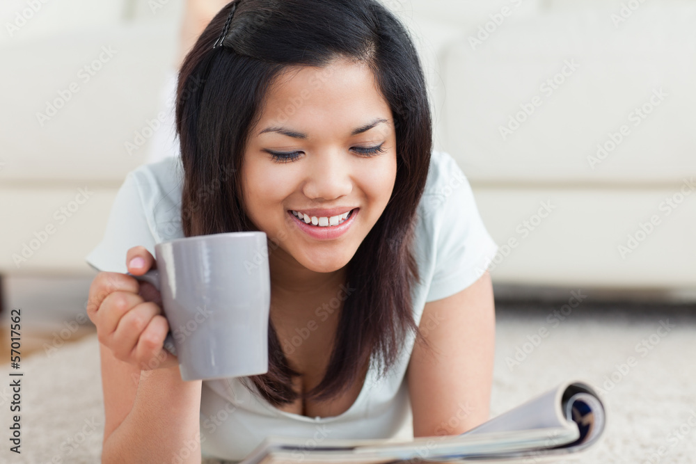 Smiling woman holding a cup and a magazine Smiling woman holding a cup and a magazine