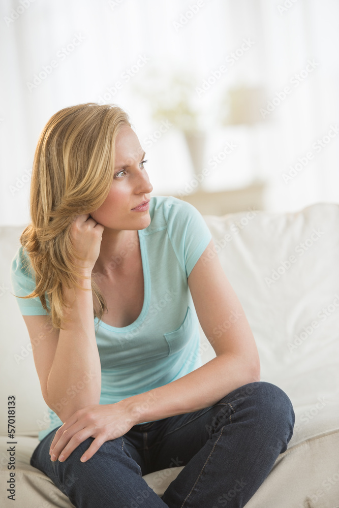 Thoughtful Woman Sitting On Sofa Thoughtful Woman Sitting On Sofa