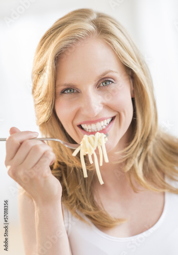 Young Woman Holding Fork With Pasta At Home