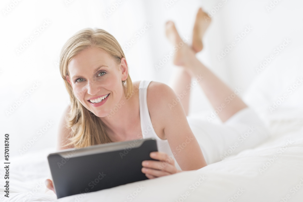 Happy Woman Holding Digital Tablet While Lying On Bed Happy Woman Holding Digital Tablet While Lying On Bed