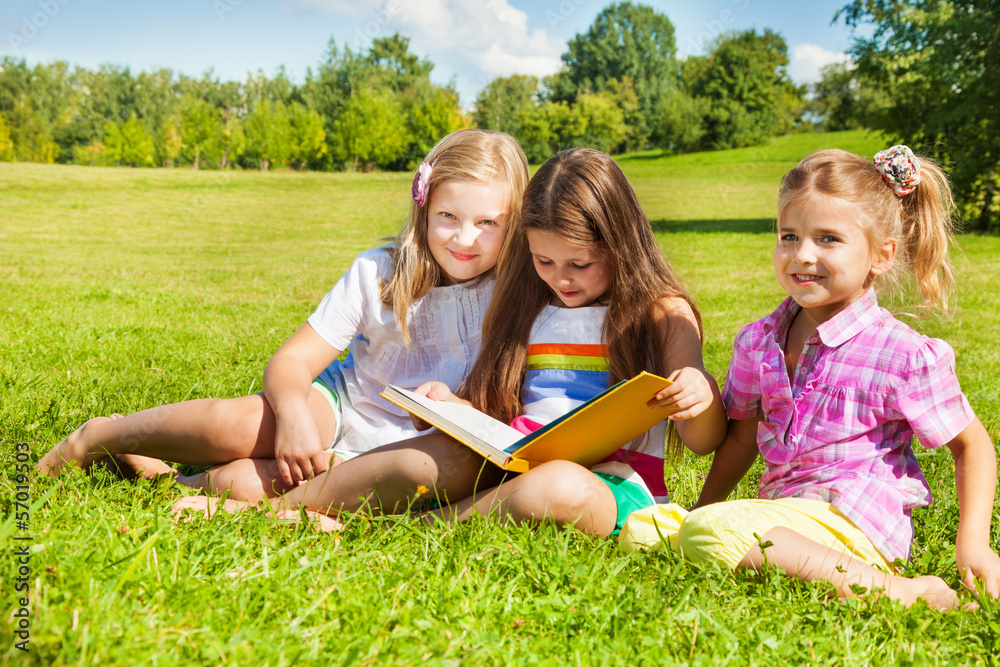 Three sisters read book in the park Three sisters read book in the park