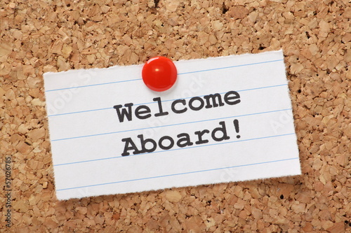 Welcome Aboard! note pinned to a cork notice board