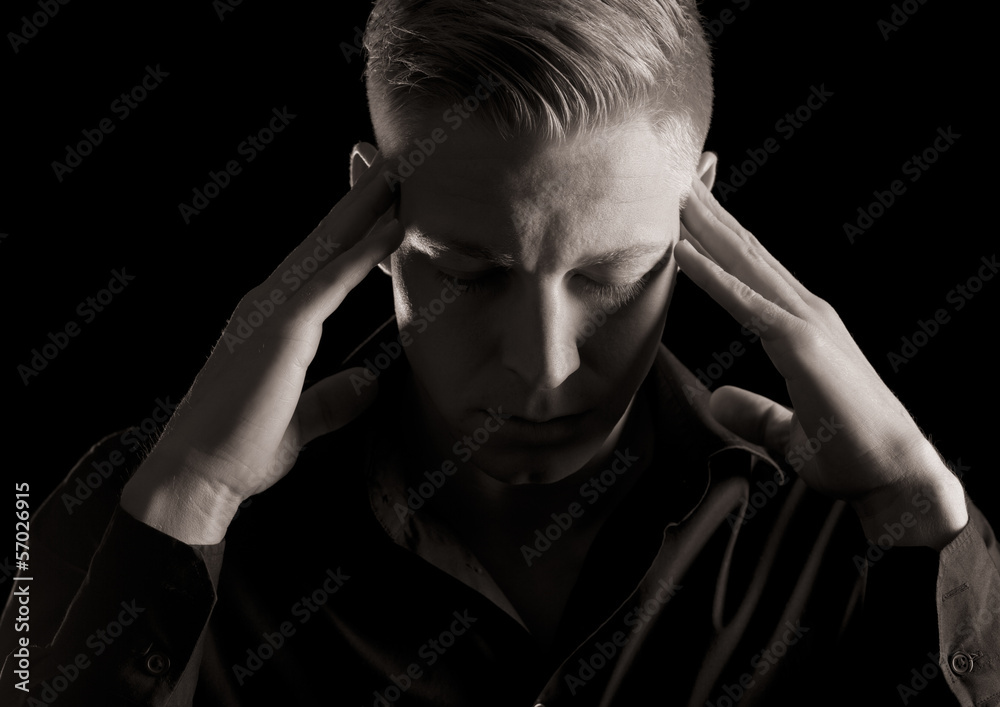 Black and white portrait of young likable man, low key. Black and white portrait of young likable man, low key.
