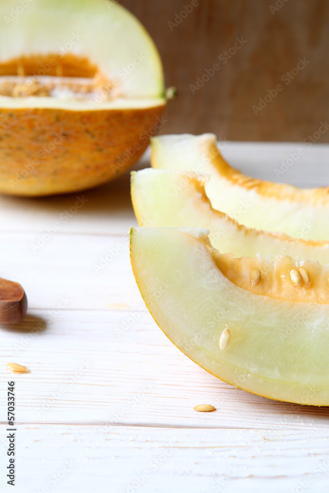 delicious slices of melon on a white wooden table delicious slices of melon on a white wooden table