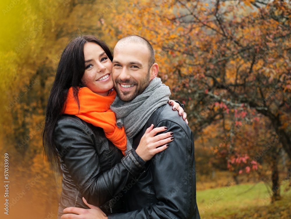 Happy middle-aged couple outdoors on beautiful autumn day