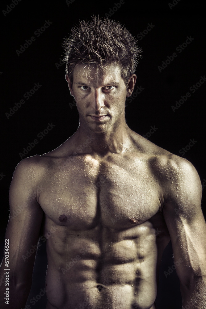 Fototapeta premium Young man with great muscles looking to the camera