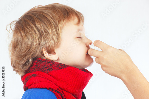Little sick boy used nasal spray in the nose