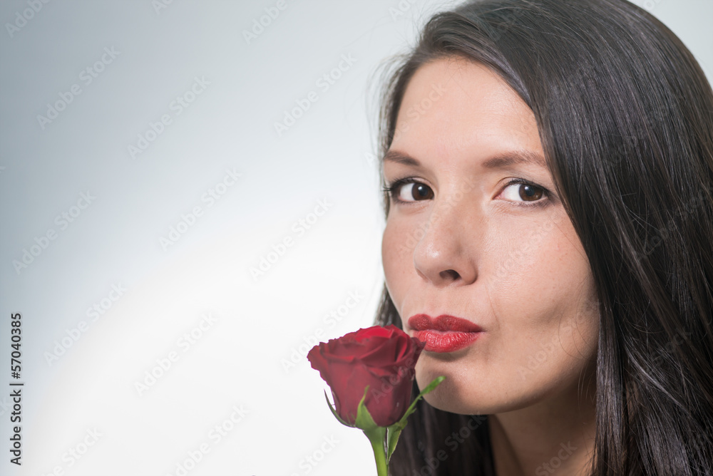 attractive woman holding a long-stemmed red rose