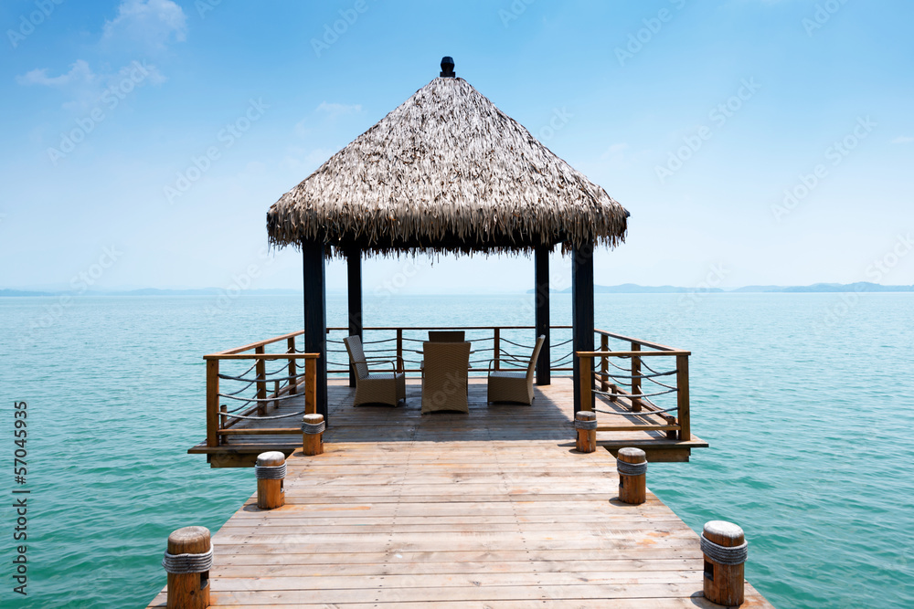 Wooden jetty over the beautiful Maldivian sea with blue sky