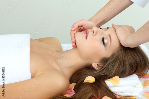 Beautiful young woman during facial massage in cosmetic salon