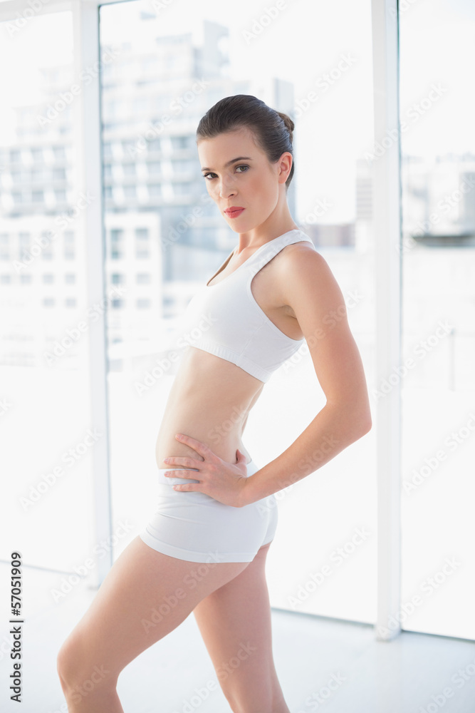 Stern fit brown haired model in sportswear posing with hands on Stern fit brown haired model in sportswear posing with hands on