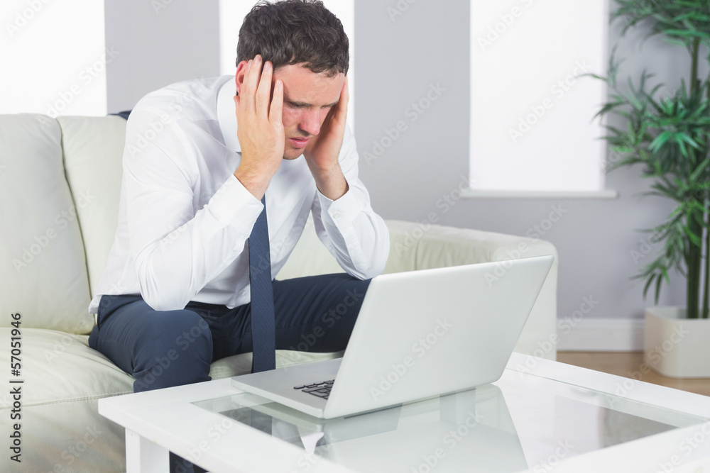 Upset handsome businessman working at laptop Upset handsome businessman working at laptop