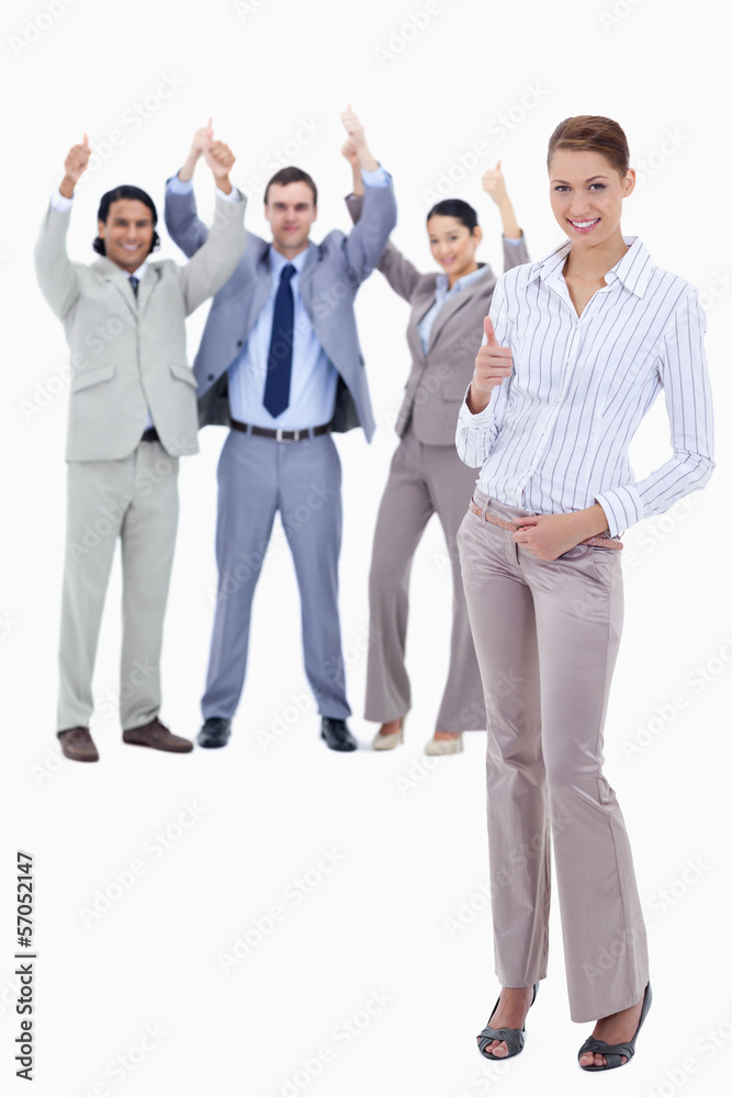 Secretary in foreground and business people with their thumbs up Secretary in foreground and business people with their thumbs up