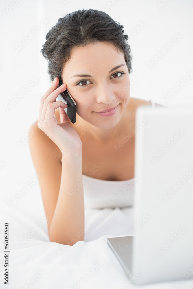 Content casual brunette in white pajamas making a phone call Content casual brunette in white pajamas making a phone call