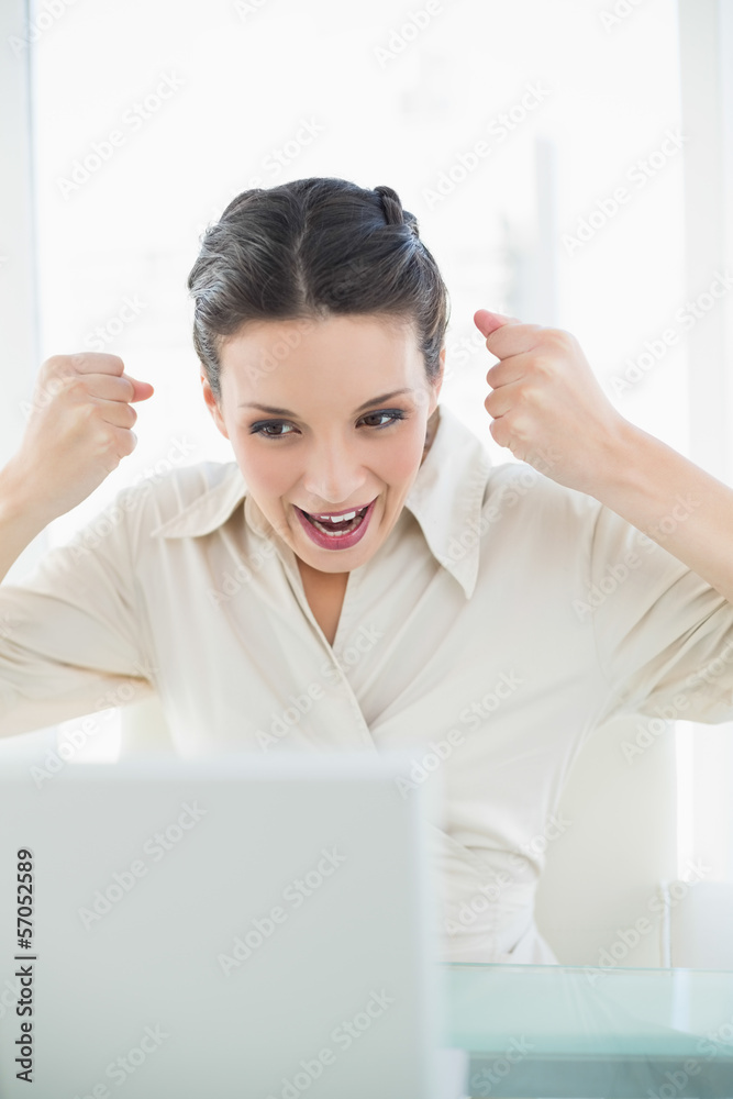 Motivated stylish brunette businesswoman raising her fists Motivated stylish brunette businesswoman raising her fists