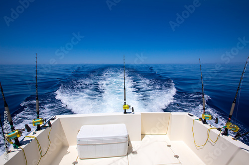 Fishing boat stern deck with trolling fishing rods and reels