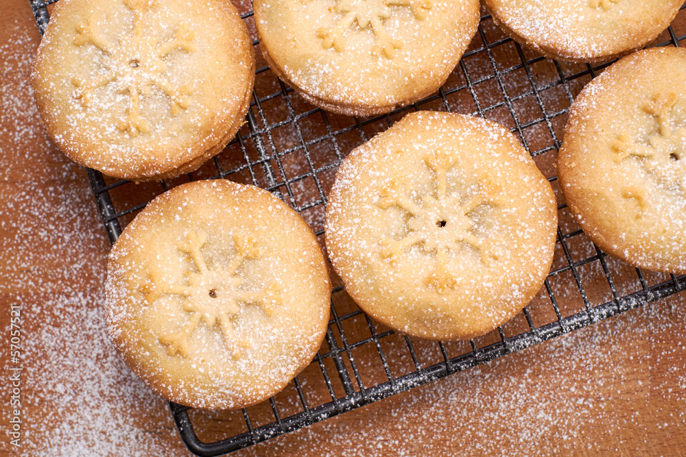 Sweet Christmas mince pies on a Baking tray and wooden board.
