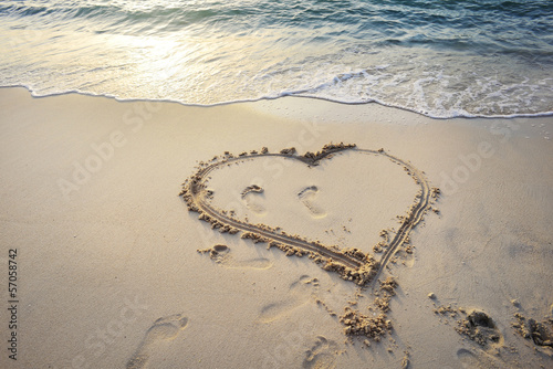 Heart written on sand.