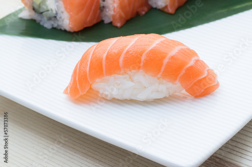 Salmon sushi nigiri on white plate with philadelphia roll