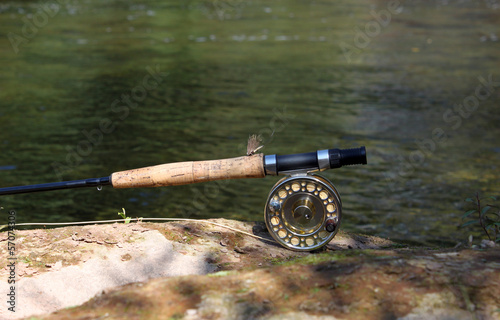 Fly fishing rod on the stone by the river