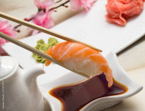 Salmon sushi nigiri with soy sauce ginger wasabi and chopsticks