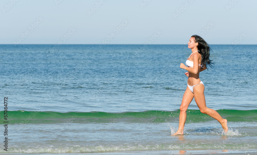 Sensual brunette running on the beach. Place for text. Sensual brunette running on the beach. Place for text.