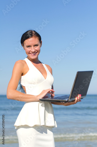 Attractive woman with notebook on the beach