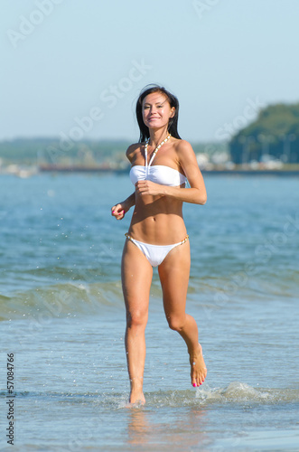 Pretty woman running along the beach