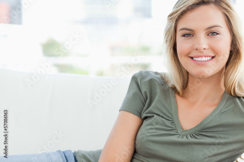Woman smiling while lying across the couch Free Download Woman smiling while lying across the couch - GFXLoad
