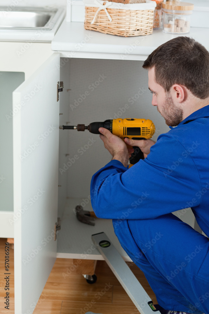 Portrait of a handyman fixing a door Portrait of a handyman fixing a door