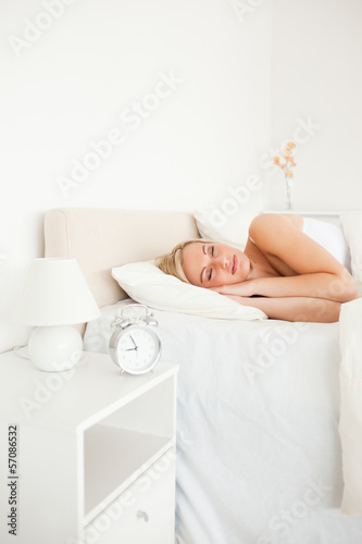 Portrait of a woman sleeping and an alarm clock