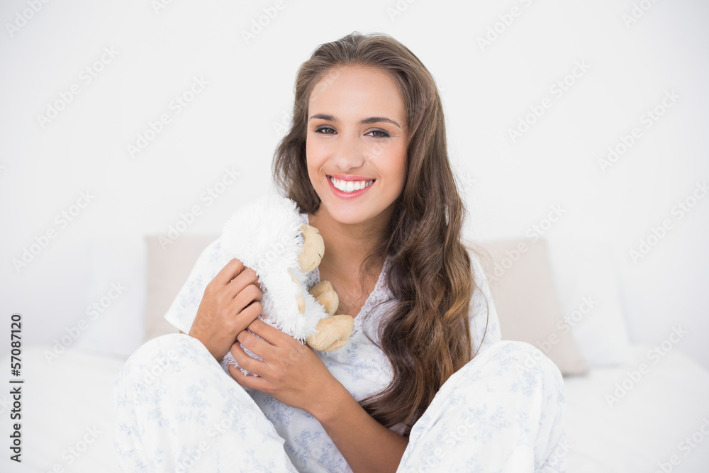 Smiling attractive brunette holding a soft toy Smiling attractive brunette holding a soft toy