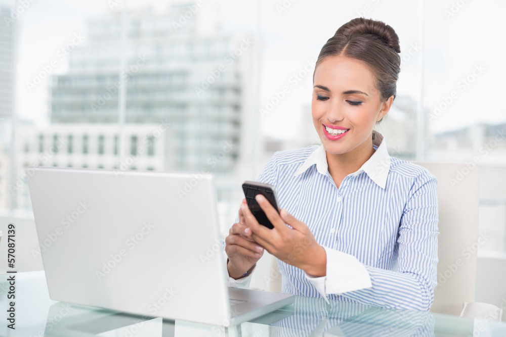 Smiling brunette businesswoman looking at smartphone Smiling brunette businesswoman looking at smartphone