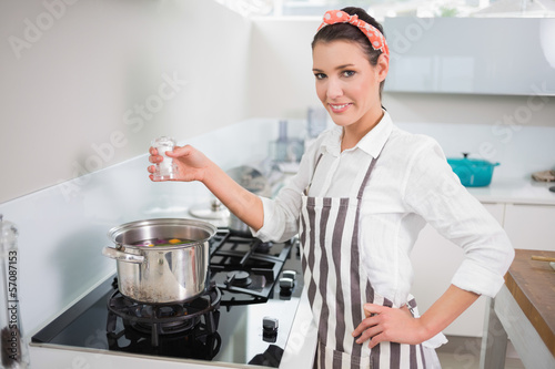 Quadro em tela Happy gorgeous cook putting salt on vegetables