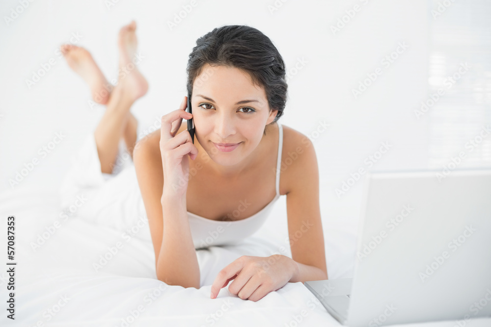 Pretty casual brunette in white pajamas making a phone call and Pretty casual brunette in white pajamas making a phone call and