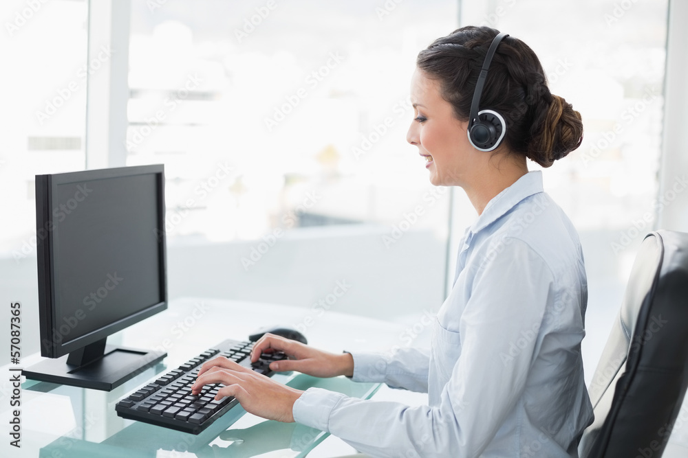 Smiling stylish brunette operator using a computer Smiling stylish brunette operator using a computer