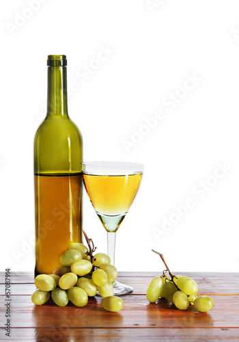 Bottle of white wine and grape bunches isolated over white