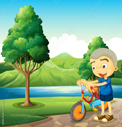 A cute little boy playing with his bike