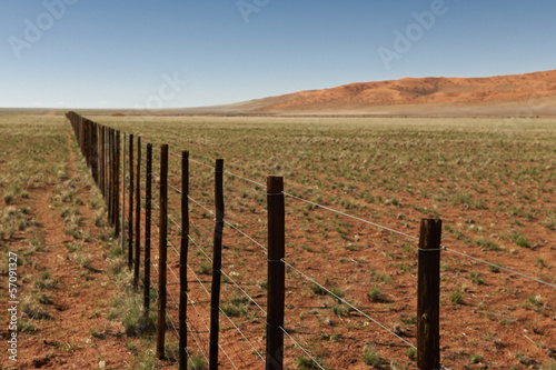 endloser Zaun durch Wuestenlandschaft der Namib, Namibia,Africa