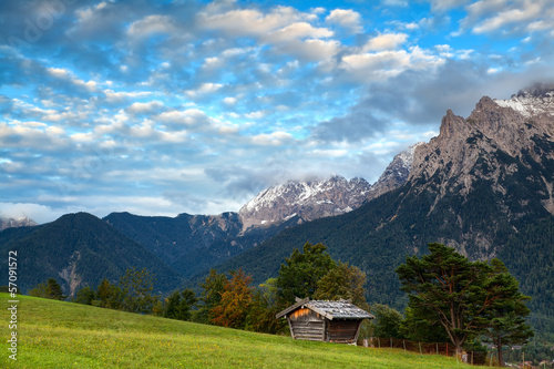 hut on meadow and Karwendel mountain range by Mittenwald