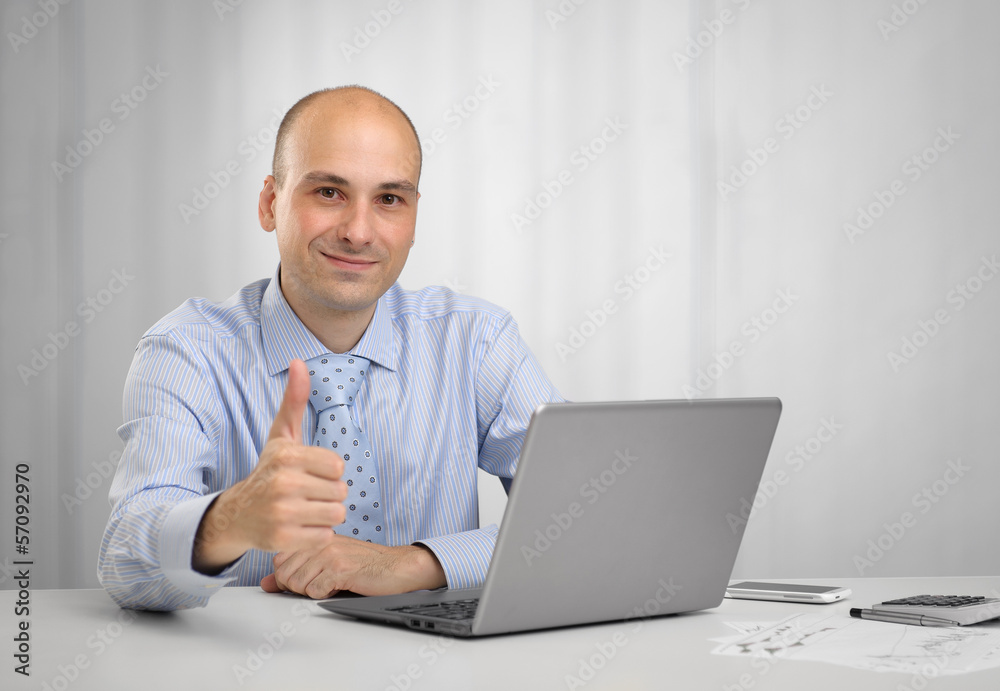Businessman with laptop showing thumbs up Businessman with laptop showing thumbs up