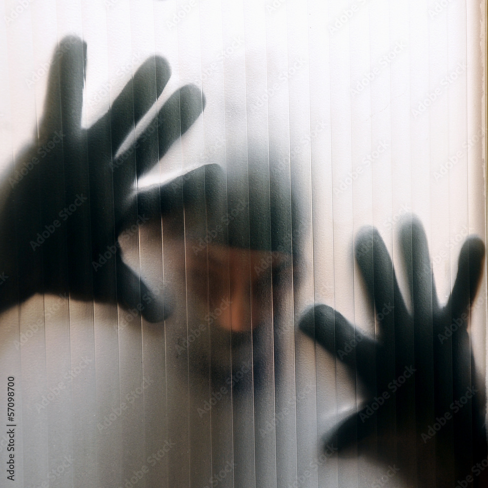 Einbrecher hinter Glasscheibe Stock-Foto | Adobe Stock