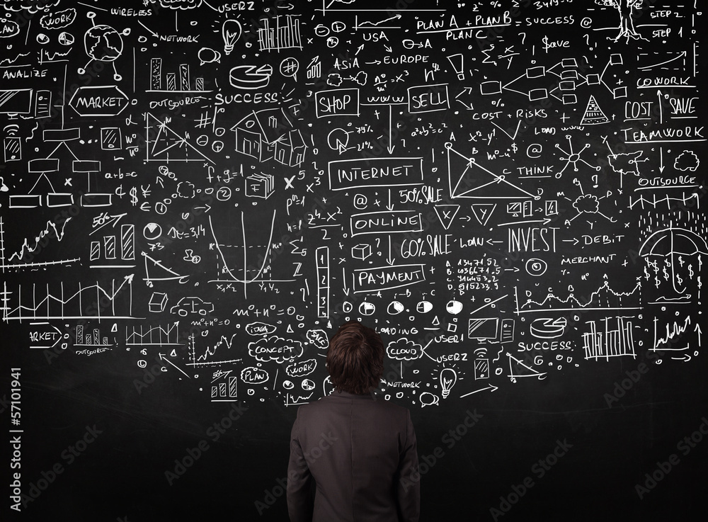 Businessman standing in front of drawn charts on a blackboard Businessman standing in front of drawn charts on a blackboard