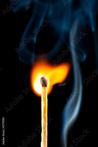 igniting match with smoke, black background