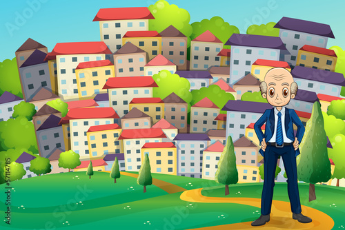 An old businessman standing at the hilltop across the buildings