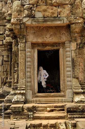 Buddhist nun covers her head in a temple in angkor