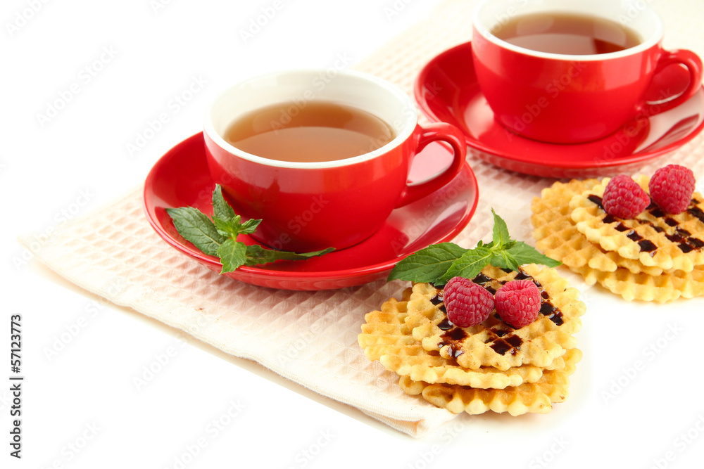 Cups of tea with cookies and raspberries isolated on white Cups of tea with cookies and raspberries isolated on white