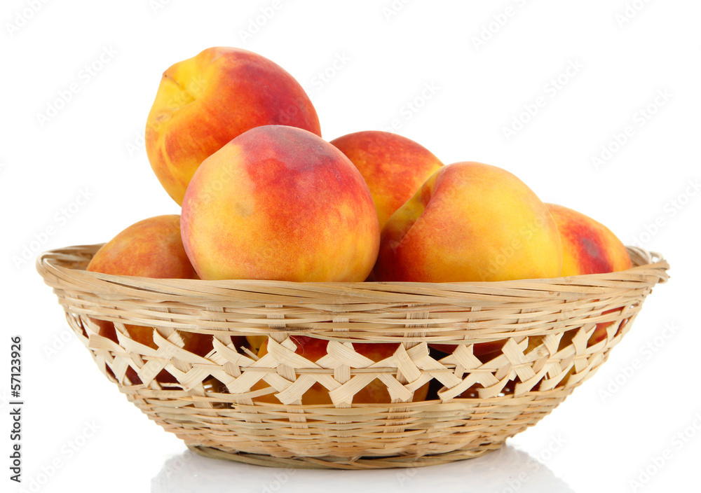 Ripe sweet peaches in wicker basket, isolated on white Ripe sweet peaches in wicker basket, isolated on white